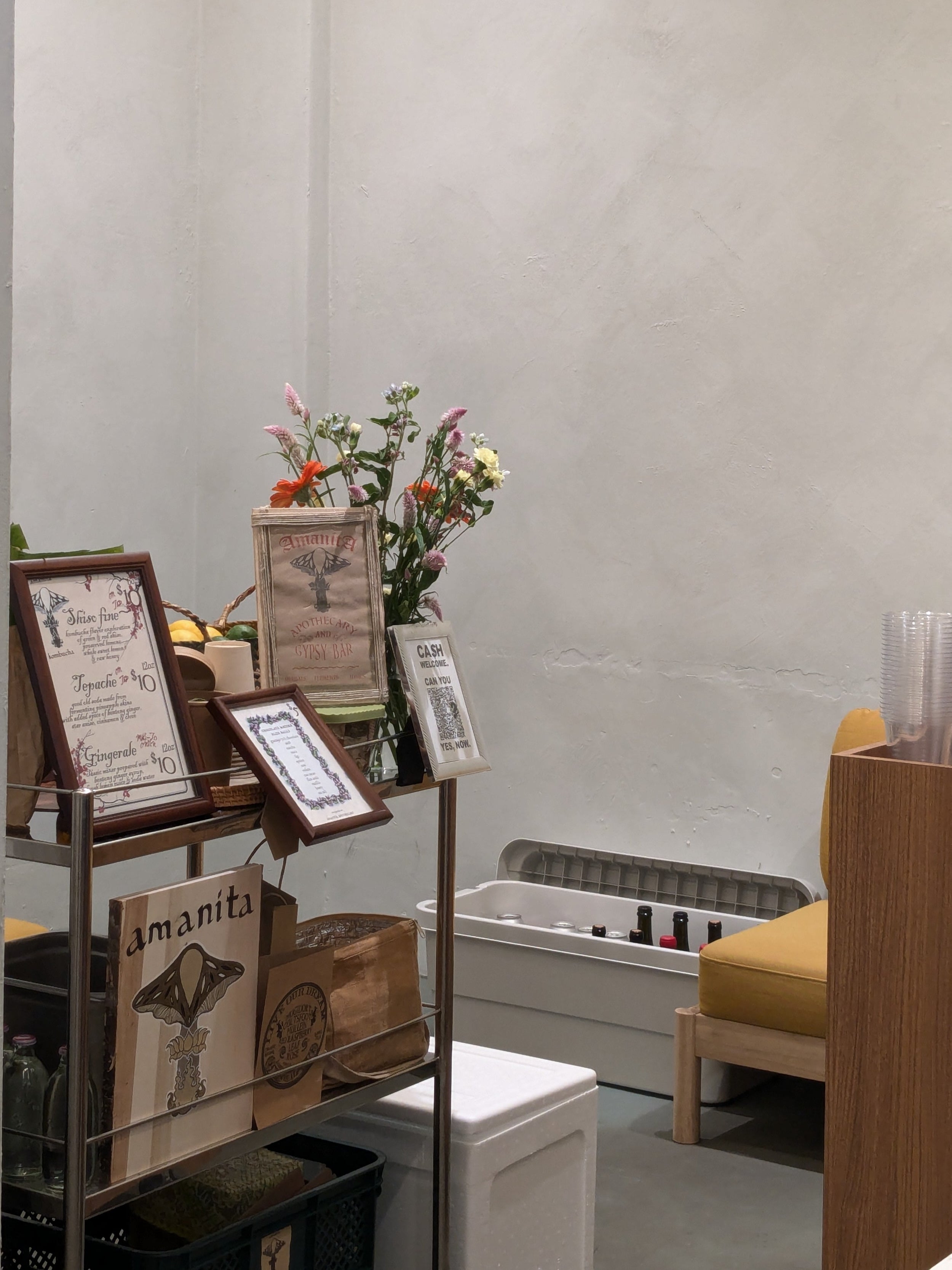 Beautifully designed kombucha booth at an event space featuring organic kombucha, custom menus, and floral decorations, creating an inviting atmosphere for guests